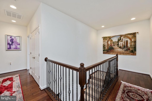 corridor with visible vents, baseboards, an upstairs landing, recessed lighting, and wood-type flooring