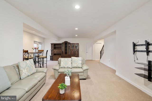 living area featuring recessed lighting, baseboards, light carpet, and stairway