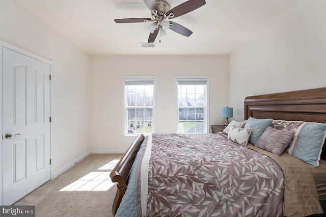 carpeted bedroom with visible vents, a ceiling fan, and baseboards