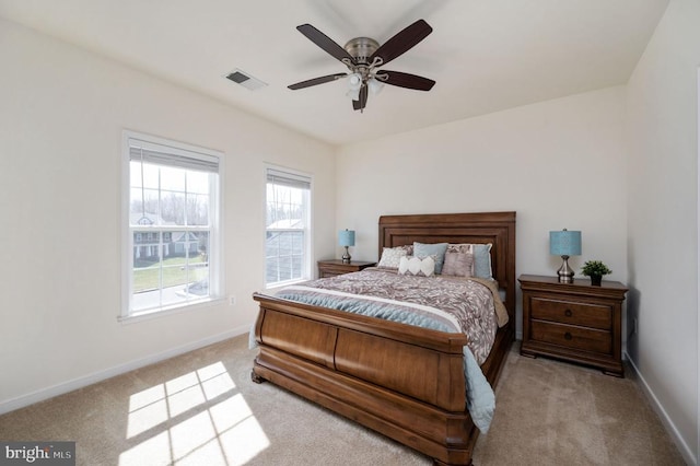 carpeted bedroom with visible vents, baseboards, and ceiling fan