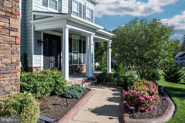 entrance to property with stone siding and covered porch