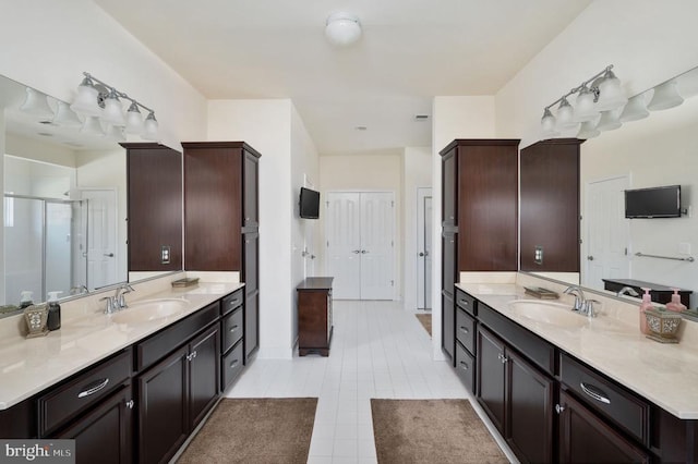 full bath with tile patterned floors, two vanities, and a sink