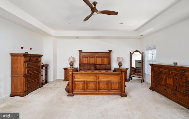 bedroom featuring recessed lighting, a tray ceiling, baseboards, and light colored carpet