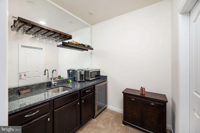 bar featuring baseboards, wet bar, a sink, wine cooler, and stainless steel microwave