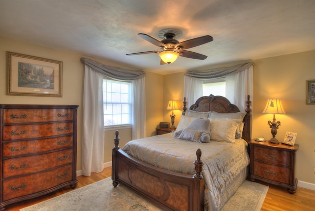 bedroom with baseboards, light wood-style flooring, and ceiling fan