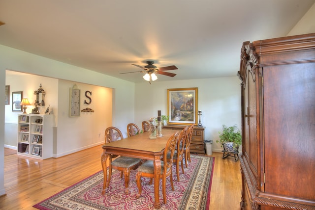 dining room featuring baseboards, ceiling fan, and light wood-style flooring