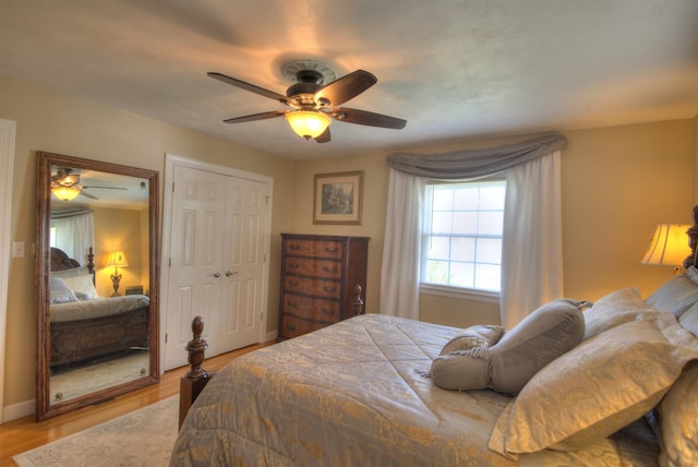 bedroom with light wood-type flooring, baseboards, ceiling fan, and a closet