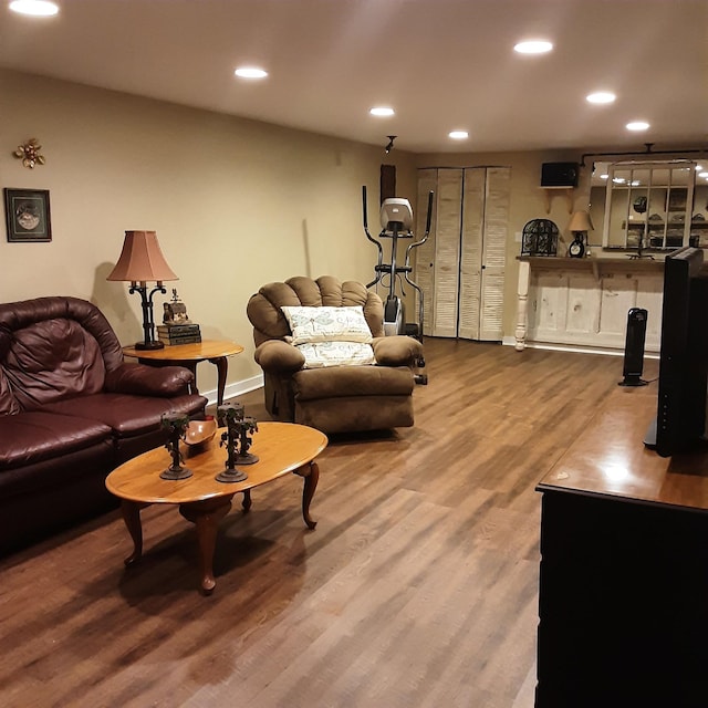 living area with recessed lighting, baseboards, and wood finished floors