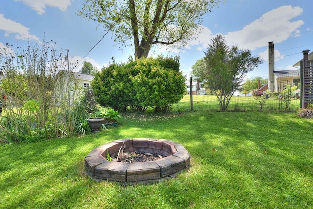 view of yard with fence and a fire pit