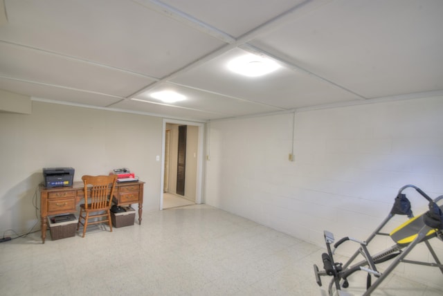 finished basement featuring tile patterned floors and concrete block wall