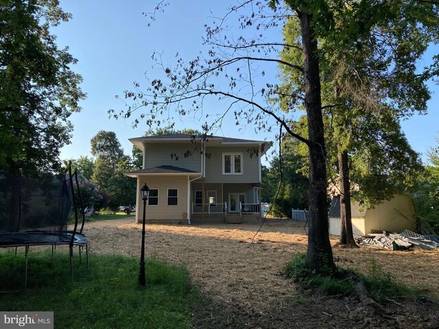 back of property featuring a trampoline and a porch