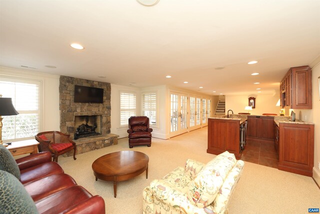 living room with crown molding, a fireplace, light carpet, and indoor wet bar