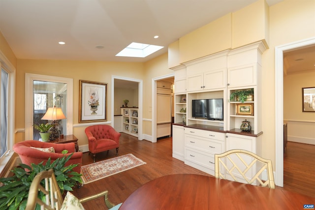 living room featuring dark hardwood / wood-style floors and vaulted ceiling with skylight