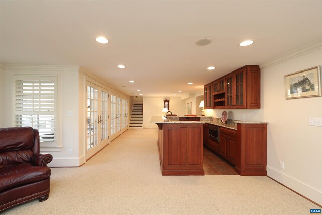 kitchen with light carpet, ornamental molding, kitchen peninsula, and oven