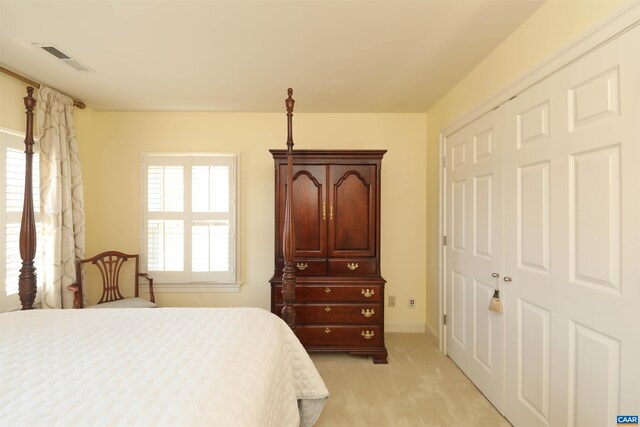 bedroom with multiple windows, light carpet, and a closet