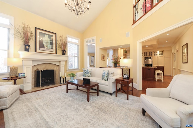 living room with an inviting chandelier, plenty of natural light, high vaulted ceiling, and wood-type flooring