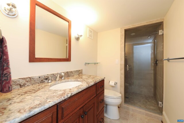 bathroom featuring vanity, tile patterned floors, a shower with door, and toilet