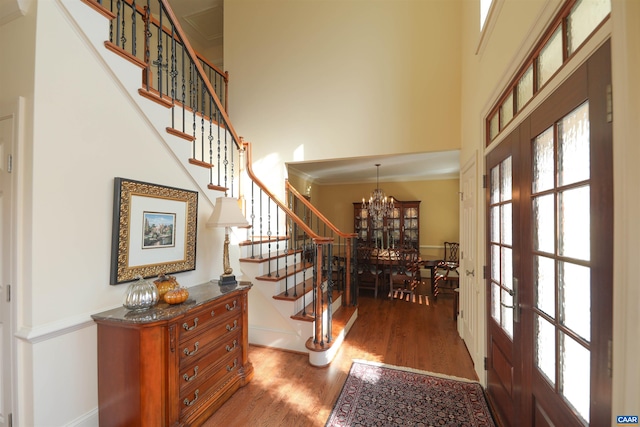 entrance foyer featuring french doors, a notable chandelier, dark hardwood / wood-style flooring, and a high ceiling