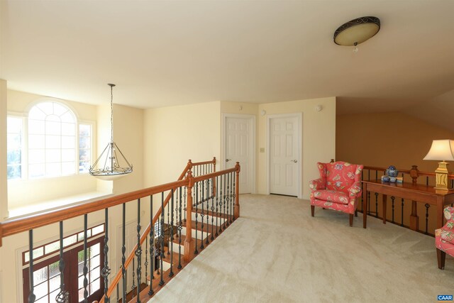 hallway with lofted ceiling and carpet floors