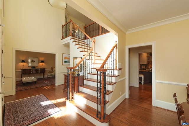 staircase featuring hardwood / wood-style floors and crown molding