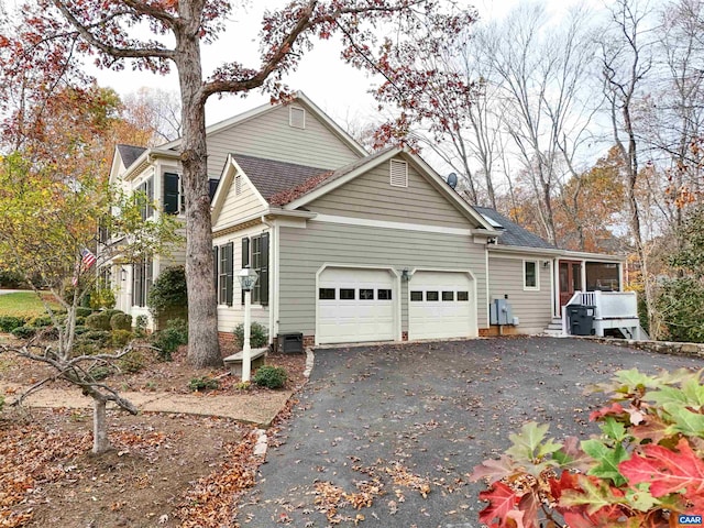 view of front of property featuring a garage and cooling unit