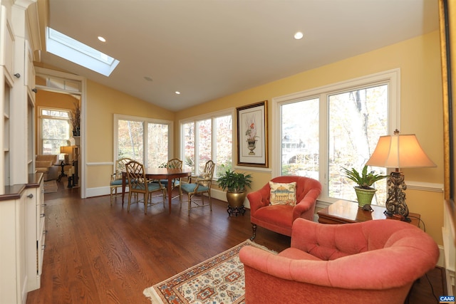 sitting room with dark hardwood / wood-style floors and lofted ceiling with skylight