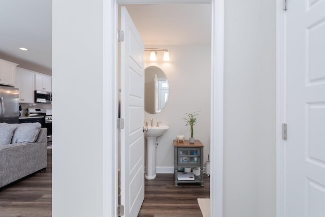 corridor featuring recessed lighting, dark wood finished floors, and baseboards