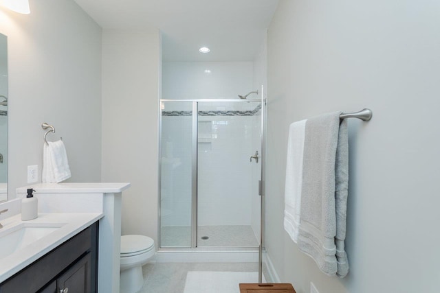 bathroom featuring tile patterned floors, a stall shower, vanity, toilet, and recessed lighting