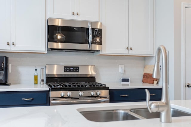 kitchen featuring white cabinets, tasteful backsplash, stainless steel appliances, and a sink