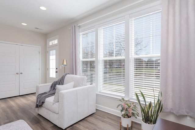 living area featuring recessed lighting, wood finished floors, visible vents, and baseboards