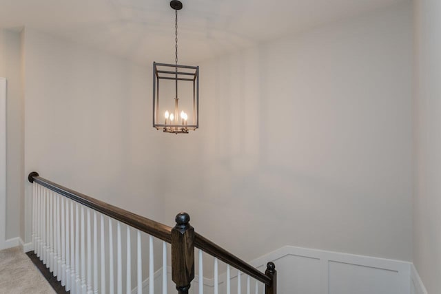 details with carpet flooring, a notable chandelier, and wainscoting