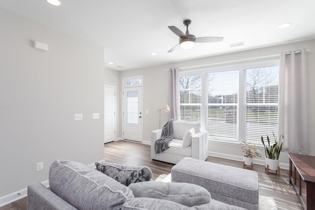 living area featuring recessed lighting, visible vents, and baseboards