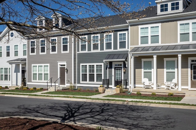townhome / multi-family property featuring a porch and a standing seam roof