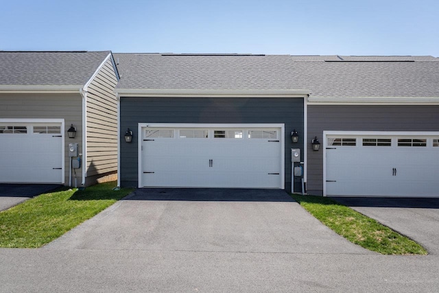 exterior space featuring driveway and a shingled roof