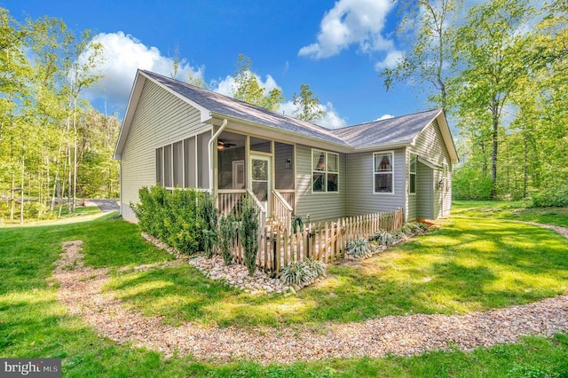 view of home's exterior featuring a sunroom and a yard
