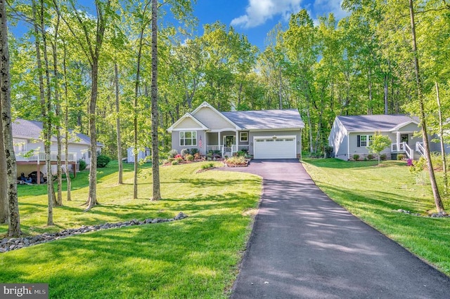 ranch-style home featuring covered porch, an attached garage, a front yard, and aphalt driveway
