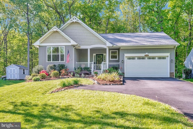 view of front of house with a storage unit, a front lawn, a garage, covered porch, and driveway