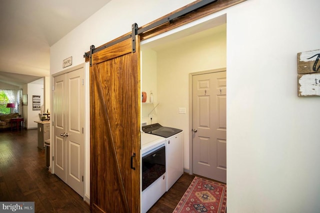 washroom with separate washer and dryer, laundry area, dark wood-style floors, and a barn door