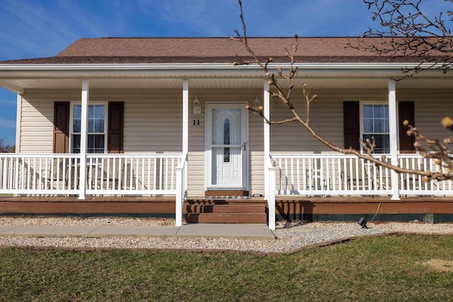 view of front of home featuring covered porch and a shingled roof