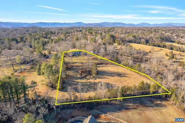 drone / aerial view featuring a wooded view and a mountain view