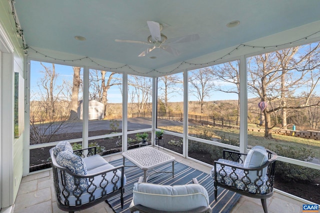 sunroom with a rural view and ceiling fan