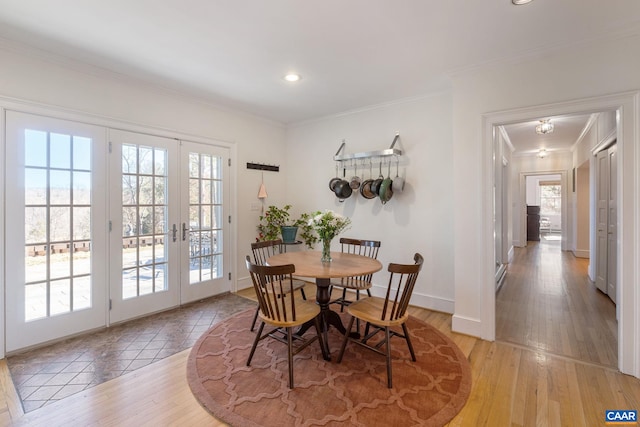 dining space featuring french doors, light wood-style floors, and a healthy amount of sunlight