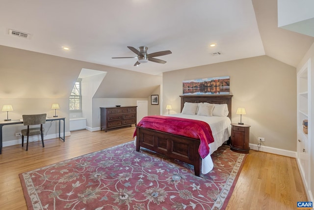 bedroom featuring visible vents, baseboards, wood finished floors, and vaulted ceiling