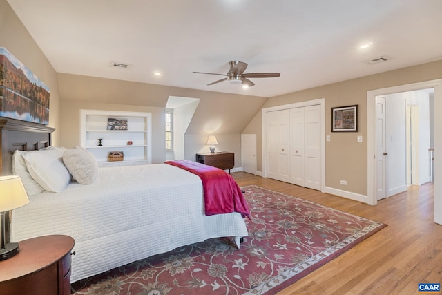 bedroom featuring a ceiling fan, wood finished floors, visible vents, and baseboards