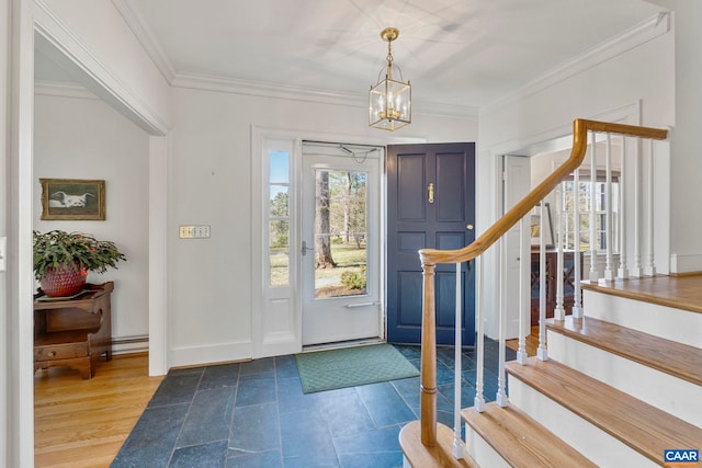 foyer with a wealth of natural light, stairway, a notable chandelier, and ornamental molding