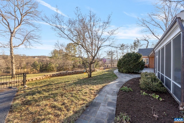 view of yard with fence and a sunroom