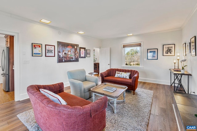 living room with crown molding, wood finished floors, and baseboards