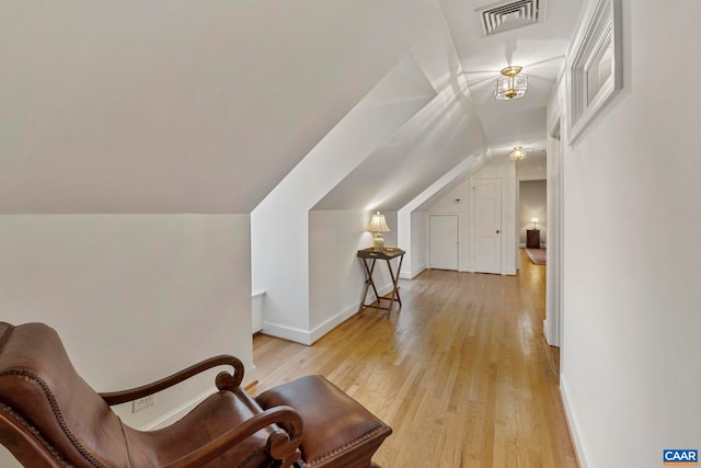 sitting room with visible vents, lofted ceiling, baseboards, and light wood-style flooring