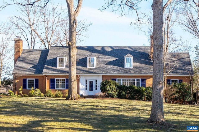 cape cod home with a front yard and brick siding