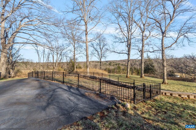 view of property's community featuring a gate, a lawn, and fence